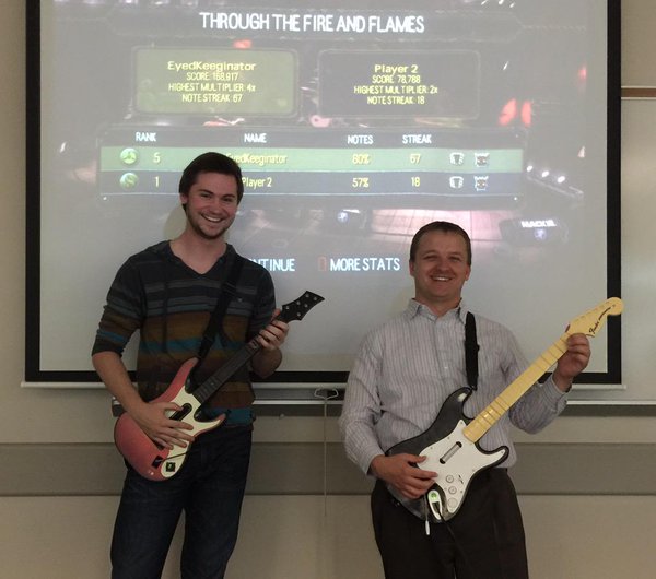 Szymon with a student holding rock band guitars